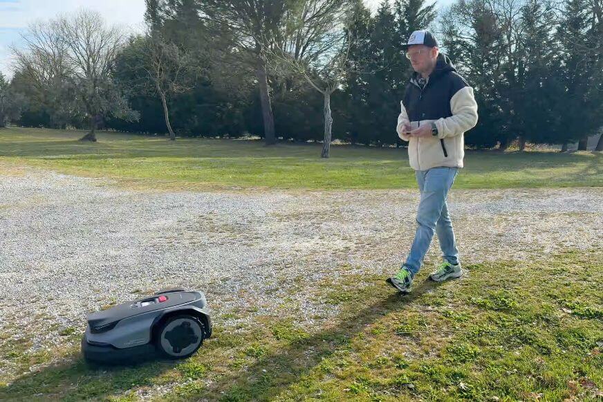 Der Smart-Home-Fox Experte läuft hinter dem Roborock RockMow S1 Mähroboter und kartiert die Außenkante des Gartens
